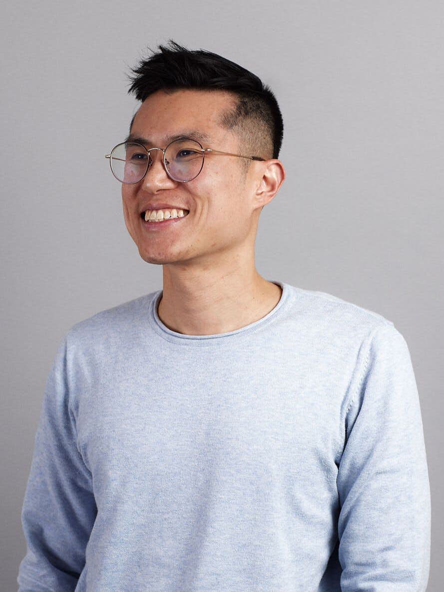 A headshot of Ming Low smiling in a pale blue sweater.