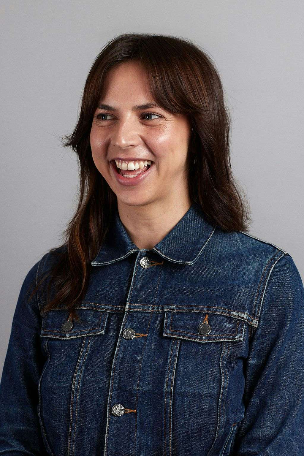 Headshot of Emma smiling and wearing a denim jacket.