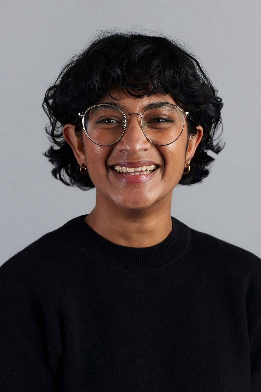 Headshot of Shehelah wearing glasses and a black top.